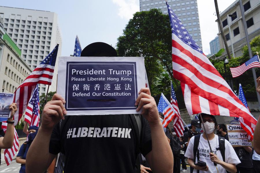 Manifestanti sventalo bandiere a stelle e strisce a Hong Kong e chiedono aiuto a Trump